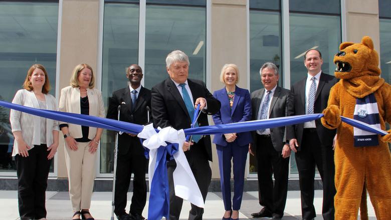 Individuals in front of Allied Health Building with mascot for ribbon cutting. 